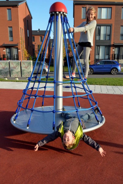 A boy spins in circles while riding a spinaround.