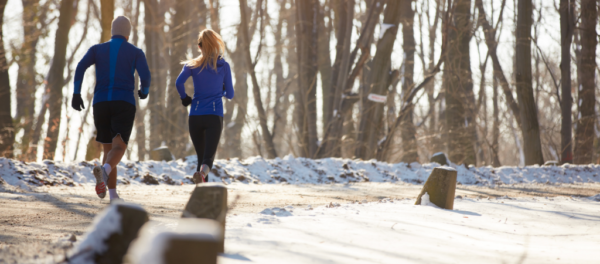 Two people running on a walking trail in the winter.