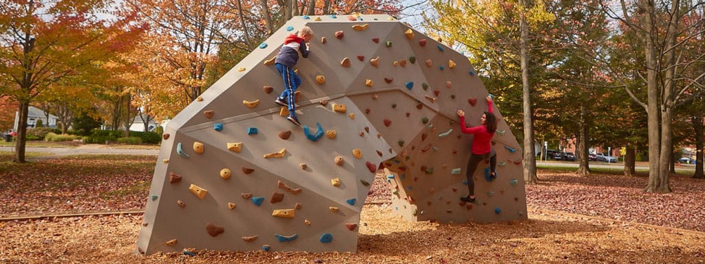 kids at an inclusive playground playing on boulder