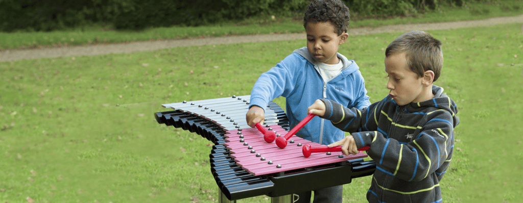 children playing with outdoor music instrument