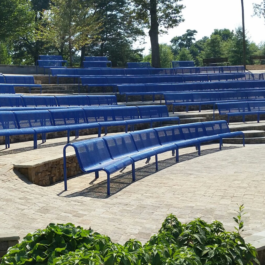 Rows of blue benches in an amphitheater.