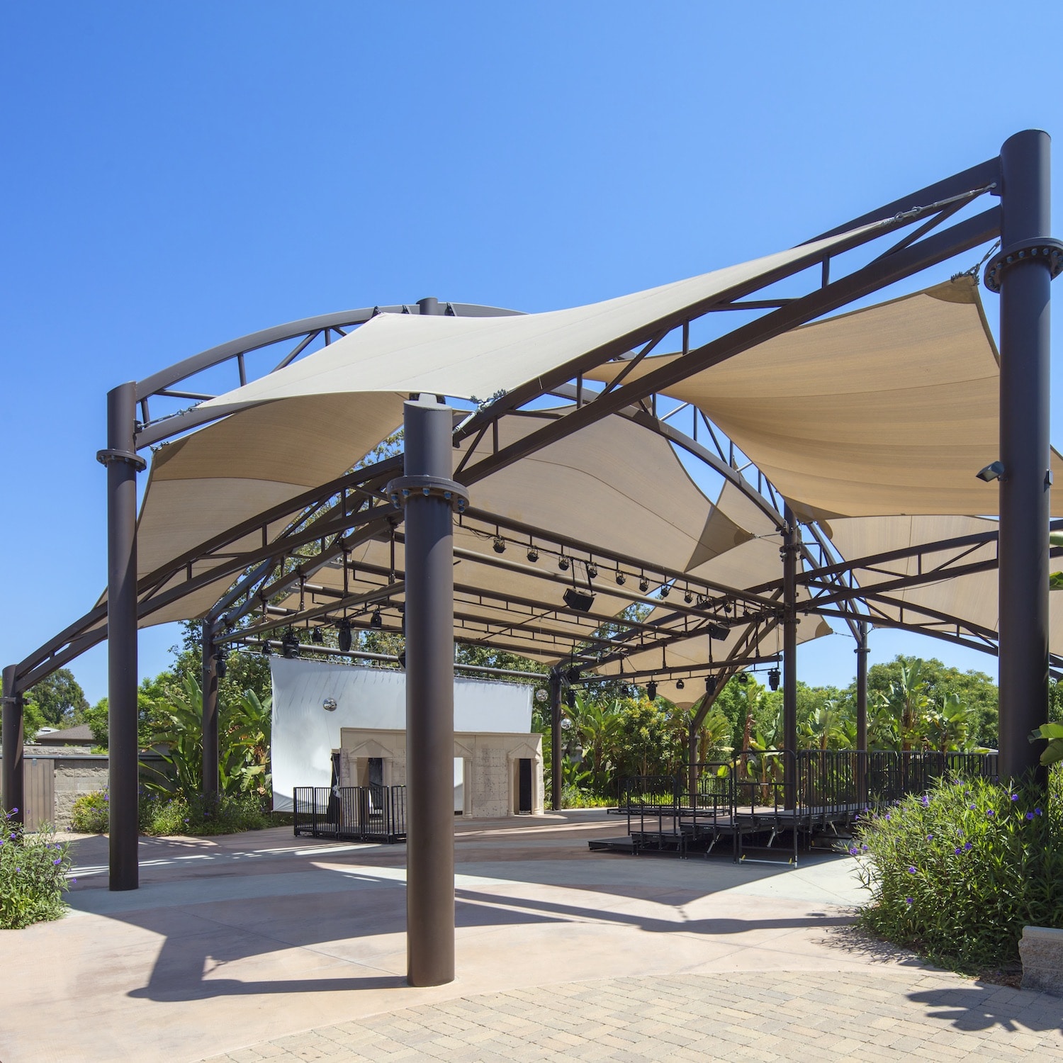 Large tan fabric shade constructed over an outdoor amphitheater.