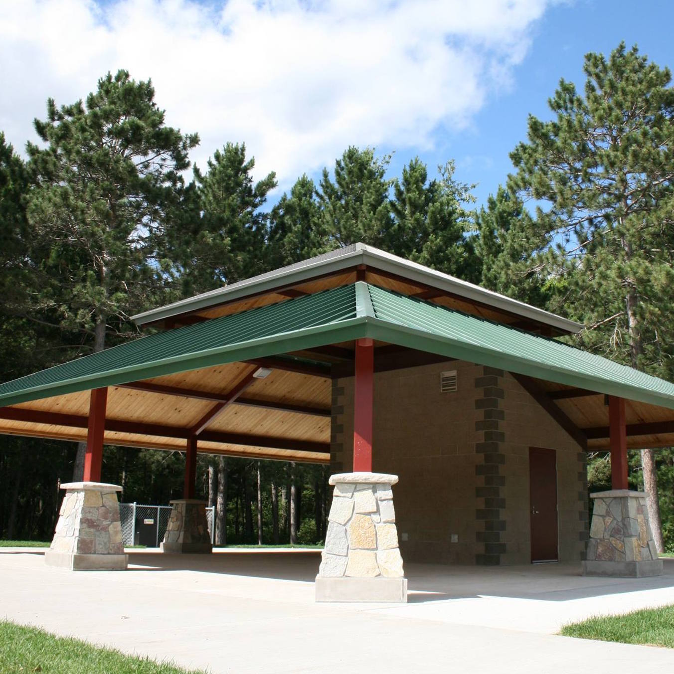 Stone pavilion with a green roof and bathrooms.