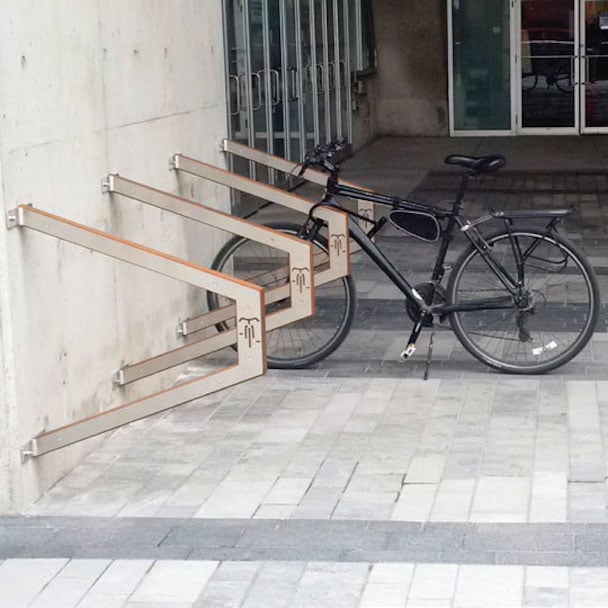 Metal bike racks fastened to the side of a building.