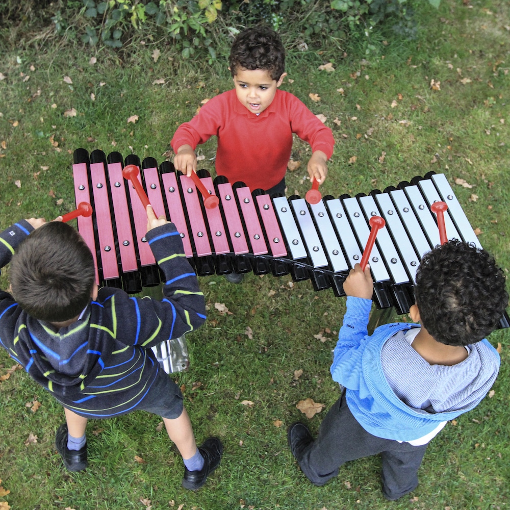 Three children make music playing on The Duo xylophone.